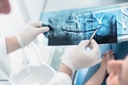 Zahnarzt zeigt im Gespräch mit Patientin ein Röntgenbild