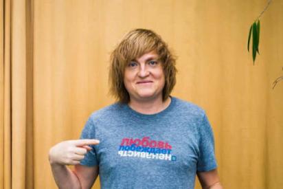 Evgeny Pisemsky von Parni Plus Russland vor einem gelben Vorhand in einem T-Shirt der Menschenrechtskampagne &quot;Love Conquers Hate&quot;