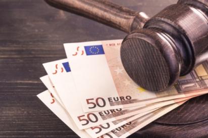 Brauner Gerichtshammer aus Holz, der auf 4 50-Euro-Banknoten abgelegt ist